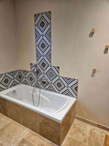 La salle de bains est pourvue d'une baignoire et de carrelage. dans l'établissement Villa climatisée avec piscine et aire de jeux enfants, à Pernes-les-Fontaines