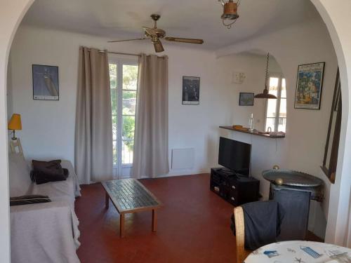 un salon avec un canapé et une table dans l'établissement Jolie appartement lumineux de 8 couchages, à Porquerolles