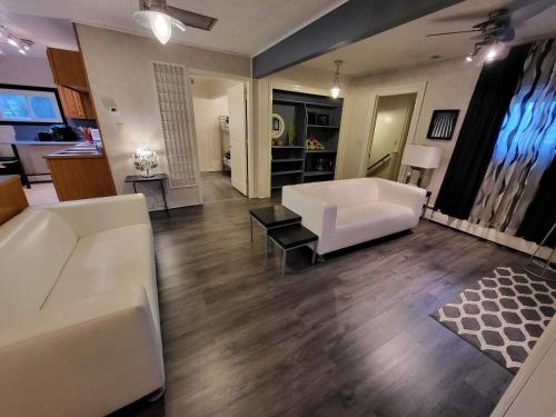 ein Wohnzimmer mit einer weißen Couch und einem Tisch in der Unterkunft Suites On Chocolate - The Annville Cottage in Annville