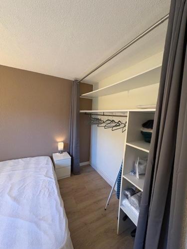 - une petite chambre avec un lit et une étagère dans l'établissement 2-Room Pool, Beach and Harbor, au Pradet