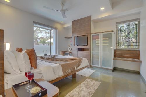 a bedroom with a king sized bed and a tv at Alaya Stays Adarsh Elegant 3-BHK Villa With Private Pool in Lonavala