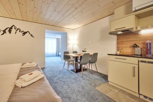 a room with two beds and a table with chairs at Aparthotel Krone - Self Check-In in Interlaken