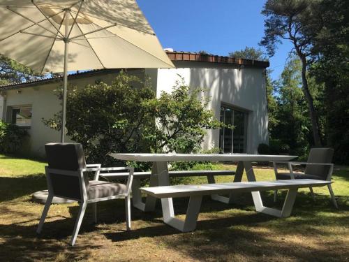 - une table de pique-nique, 2 chaises et un parasol dans l'établissement Maison d'architecte en forêt du Touquet, à Le Touquet-Paris-Plage
