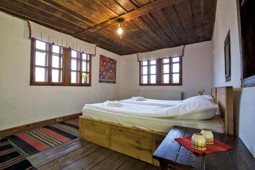 ein Schlafzimmer mit einem Bett und einem Tisch darin in der Unterkunft Incredible Cabin Getaway with Indoor and Outdoor Fireplaces in Selishte, Bulgaria in Karatsite