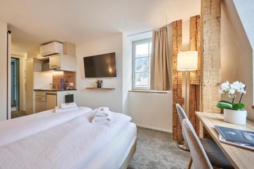 a hotel room with a bed and a table and a kitchen at Aparthotel Krone - Self Check-In in Interlaken