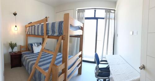 a dorm room with a bunk bed and a desk and a desk at Apartamento de playa y piscina, Mejia in Mejia