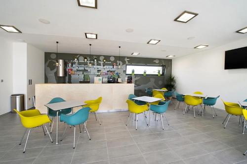 a restaurant with tables and chairs and a bar at Beachwell in Pelhřimov