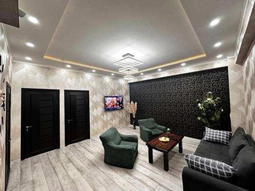 a living room with a couch and chairs and a table at Spacious apartments in the center of Dushanbe in Isfisor