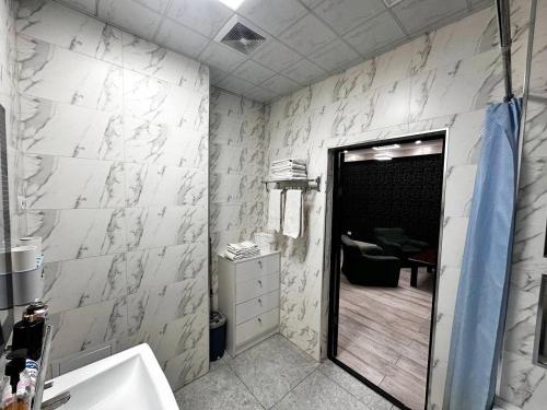 a bathroom with a sink and a door to a room at Spacious apartments in the center of Dushanbe in Isfisor