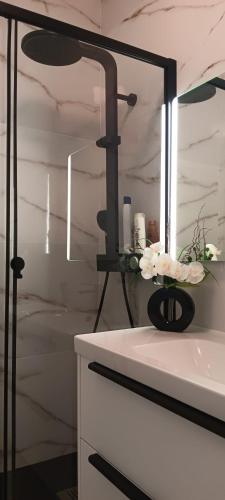 a bathroom with a mirror and a vase with flowers at Joana's room 1 in Lisbon