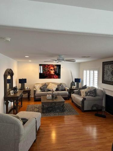 a living room with couches and a tv on the wall at Private rooms in Las Vegas