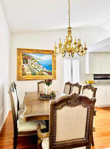 a dining room with a table with chairs and a chandelier at Private rooms in Las Vegas