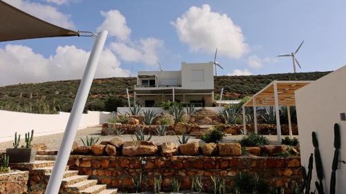 a house with two windmills in the background at CasaEole in El Haouaria