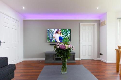 a living room with a vase of flowers on a table at Super Prime Park View Duloch By Tba in Dunfermline