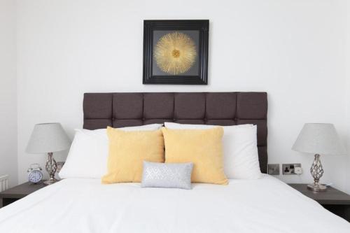 a bedroom with a large white bed with yellow pillows at Super Prime Park View Duloch By Tba in Dunfermline