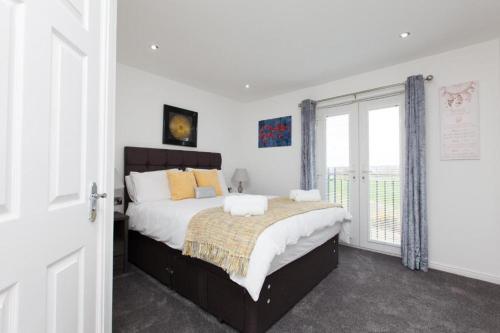 a bedroom with a large bed and a window at Super Prime Park View Duloch By Tba in Dunfermline