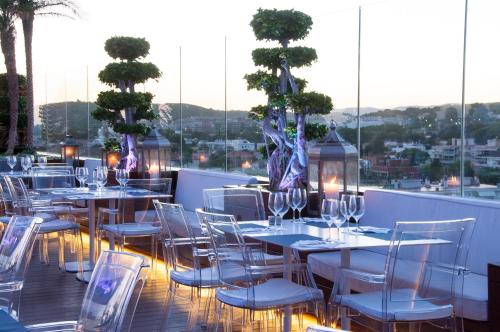 eine Reihe von Tischen und Stühlen auf einem Balkon in der Unterkunft Hotel MiM Sitges & Spa in Sitges
