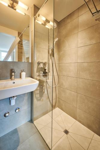a bathroom with a sink and a shower at Aparthotel Krone - Self Check-In in Interlaken