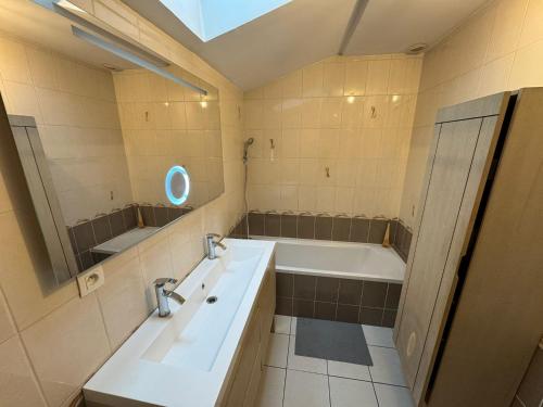 a bathroom with a bath tub and a sink and a bath tub at Spacious renovated villa Groupama Stadium LDLC in Décines-Charpieu