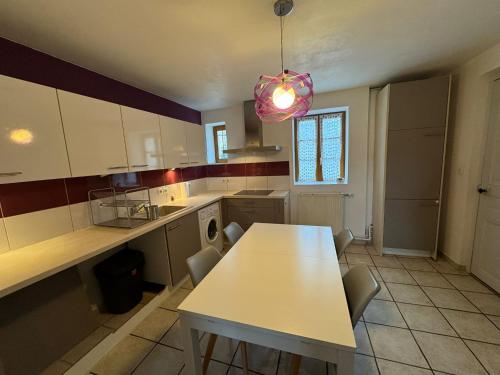 a kitchen with a table and chairs in it at Spacious renovated villa Groupama Stadium LDLC in Décines-Charpieu