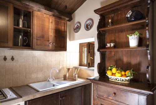 a kitchen with a sink and a basket of fruit at Borgo La Ferriera - Celleno Viterbo con Piscina in Celleno
