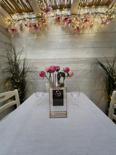 a table with two wine glasses and a vase with flowers at Vanessa Home in Burano