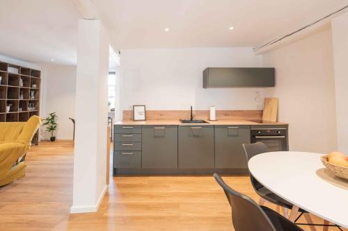 a kitchen with a table and a tv on the wall at FREYZEIT Apartments Speyer in Speyer