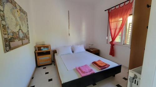 a bedroom with a bed with two towels on it at POTIDAIA BEACH HOUSE in Nea Potidaea