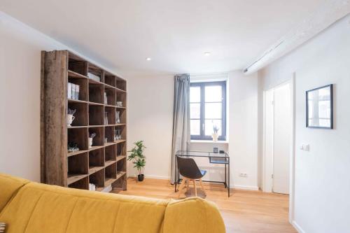 a living room with a yellow couch and a desk at FREYZEIT Apartments Speyer in Speyer