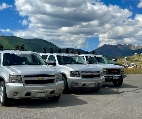 three trucks parked in a parking lot with birds on the roofs at Highest Condo in CB with Stunning Views from Porch in Crested Butte