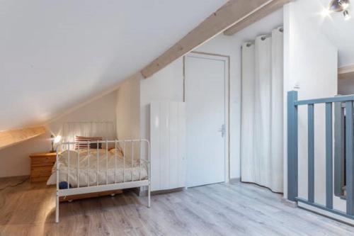a bedroom with a bed in a room with a staircase at Agréable, jardin, toute équipée, proche du marché, plage à 300m in La Baule
