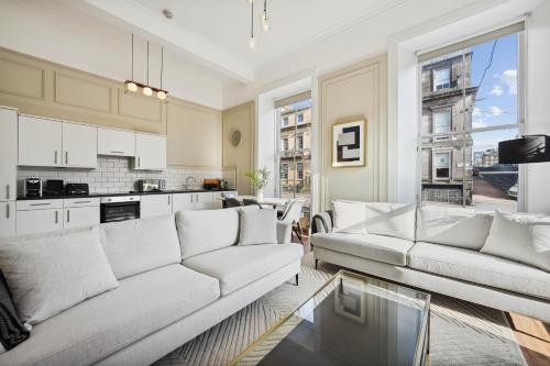 a living room with two couches and a kitchen at (G1) Elegant 2 bed Blythswood Apartment in Glasgow
