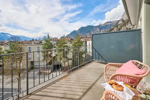 a balcony with a chair and a view of a city at Aparthotel Krone - Self Check-In in Interlaken