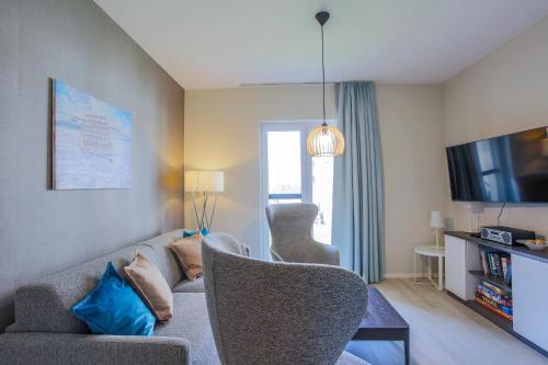 a living room with a couch and a tv at Boddenluemmel in der Seefahrtschule in Wustrow