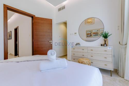a bedroom with a white bed and a mirror at Pool and Sea Views 3BR and Assistant's Room Villa with Beach Access and BBQ Facilities, Sharm - Al Dana Villa, Al Dana Island by Deluxe Holiday Homes in Fujairah