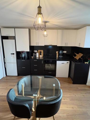 un salon avec une table en verre et des chaises dans l'établissement Le Saint Laurent apartment, à Saint-Laurent-sur-Gorre