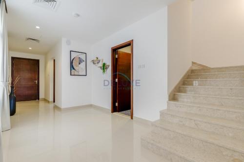 a white hallway with stairs in a house at Pool and Sea Views 3BR and Assistant's Room Villa with Beach Access and BBQ Facilities, Sharm - Al Dana Villa, Al Dana Island by Deluxe Holiday Homes in Fujairah