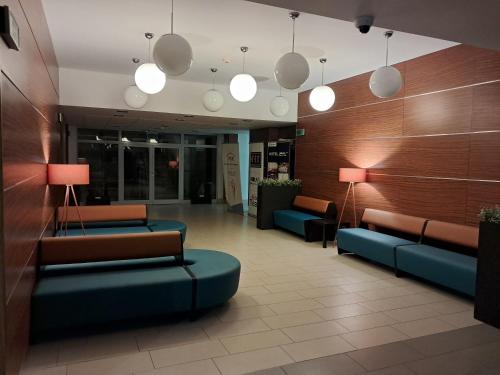 a lobby with couches and lamps in a building at Hotel Kolna - darmowy parking, basen w cenie in Krakow