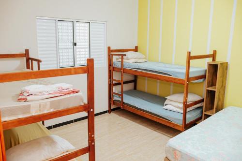a room with three bunk beds and a window at Chácara Recanto Lunar in Boituva