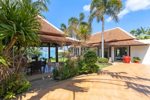 a house on the beach with palm trees at Bacaya Beachfront Villa in Bang Rak Beach