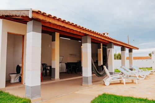 a house with a patio with chairs and a table at Chácara Recanto Lunar in Boituva