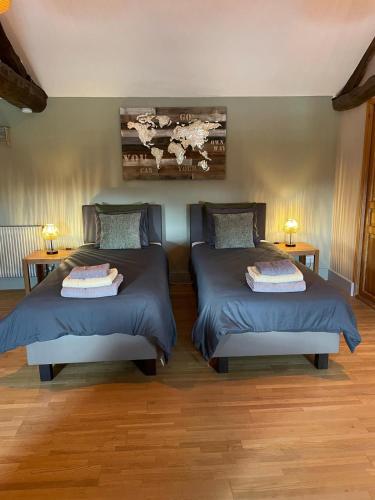 two beds in a room with two lamps on tables at Favau in Sainte-Radegonde