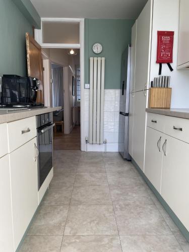 a kitchen with white cabinets and a tile floor at Harmonious Family Home in Westbury-on-Trym in Bristol