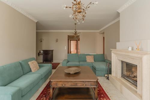 a living room with blue couches and a fireplace at Avgerinos in Makrochórion
