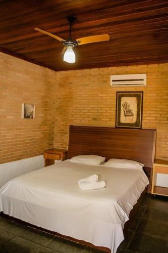 a bedroom with a large white bed with a fan at Old West Hotel Fazenda in Tremembé