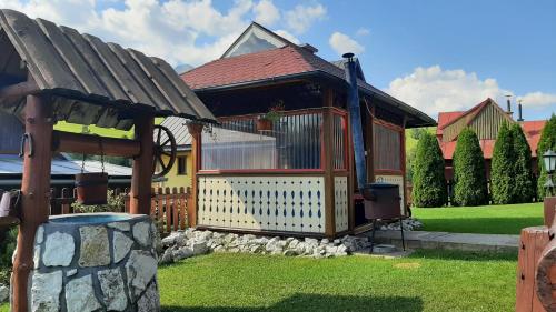 a house with a gazebo in a yard at Penzión Stodola in Ždiar