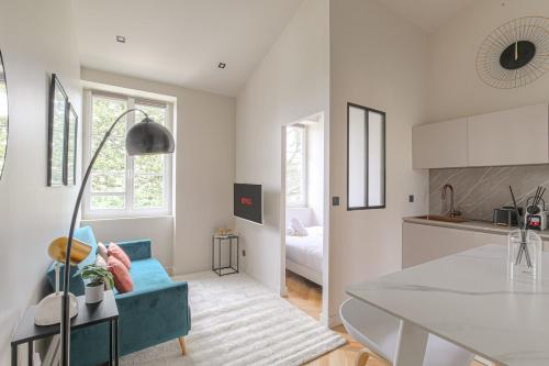 Il comprend une cuisine et un salon avec un canapé bleu. dans l'établissement T2 rénové et confortable à Écully pour 2 personnes, à Écully