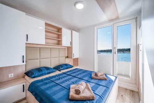 a bedroom with a bed with towels on it at Floating house - ARIA in Pula