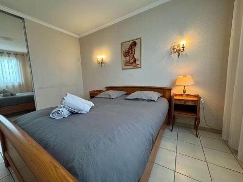 Un dormitorio con una cama y una mesa con una lámpara. en 100 m T3 with loggia - Eurexpo-Groupama Stadium, en Saint-Priest