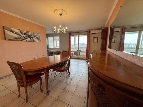 une salle à manger avec une table et des chaises en bois dans l'établissement 100 m T3 with loggia - Eurexpo-Groupama Stadium, à Saint-Priest
